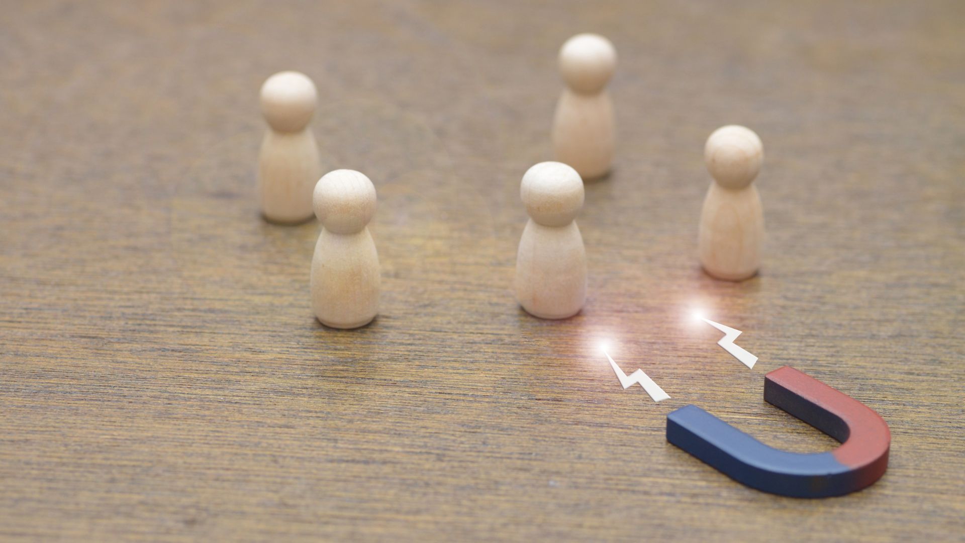 A magnet attracting small wooden figures intended to represent customers. 