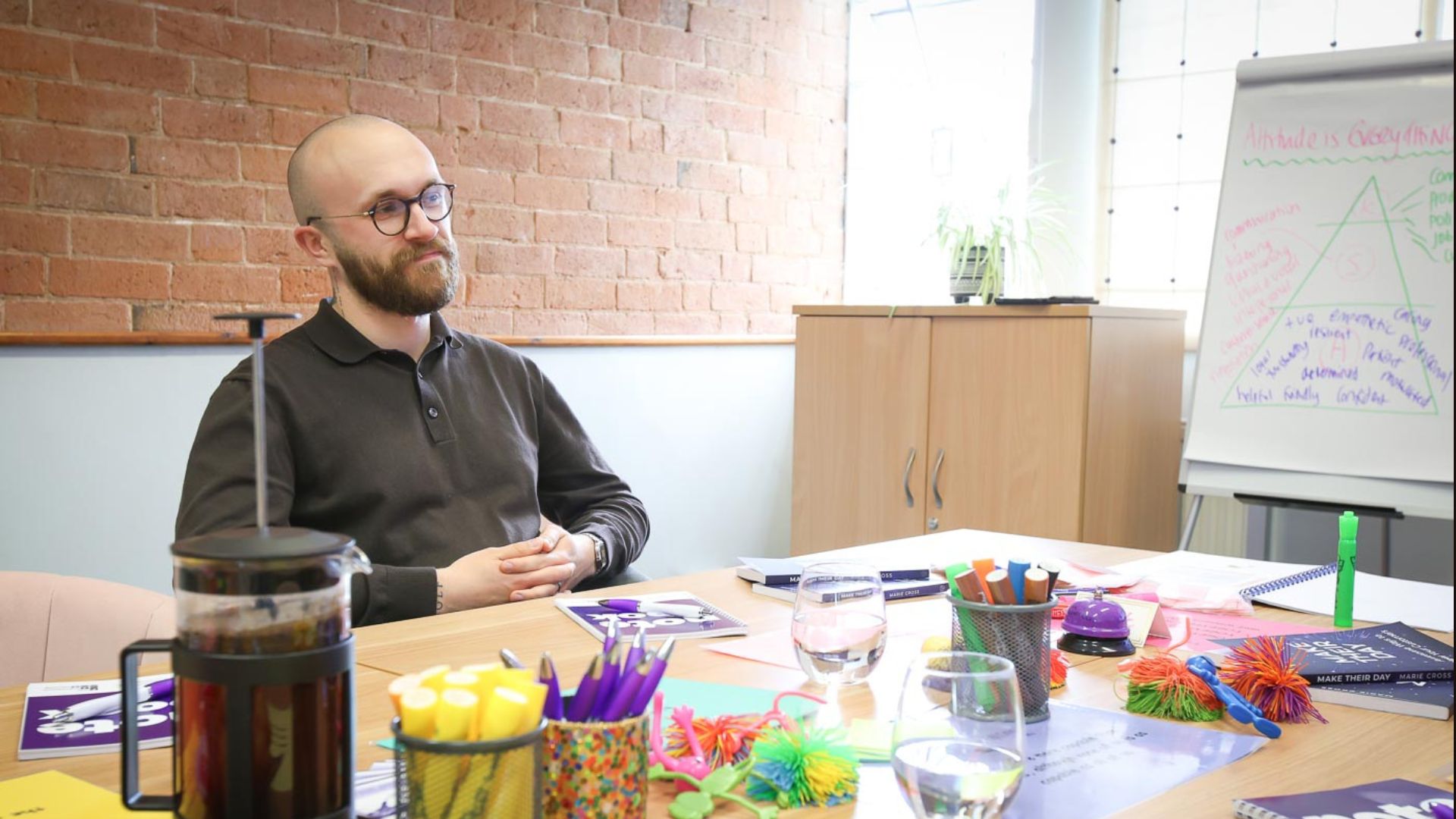 A bearded professional sitting at a table in a coaching session. 